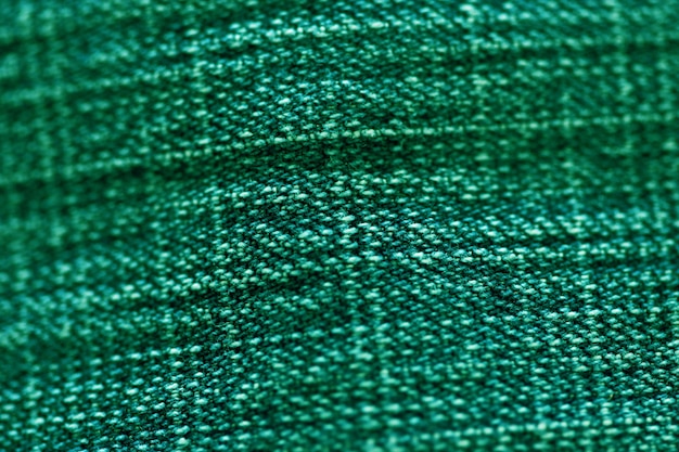 Grüne Textiltextur aus nächster Nähe, Fokus nur auf einen Punkt, weicher, unscharfer Hintergrund