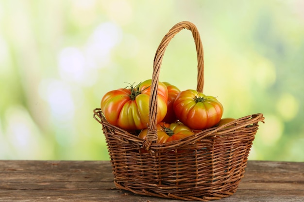 Grüne Tomaten im Korb auf hellem Hintergrund