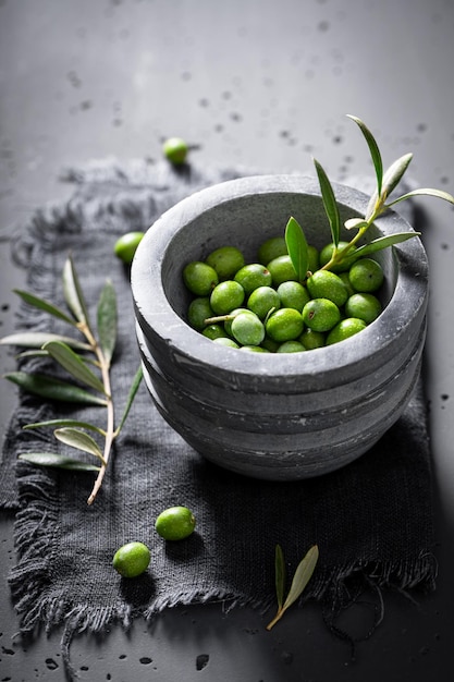 Grüne und kleine rohe Oliven als Zutat von Olivenöl