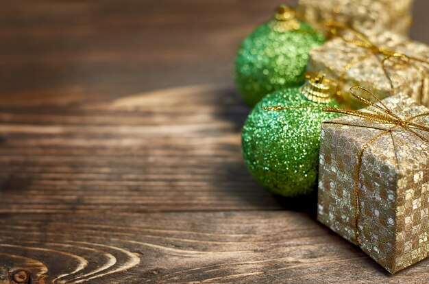 Grüne Weihnachtskugel Goldene Geschenkbox auf Holzuntergrund