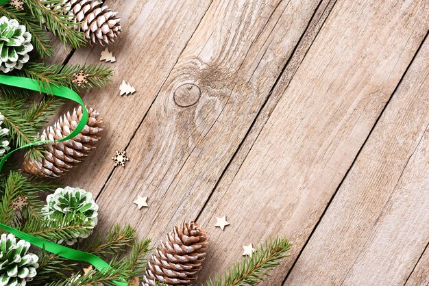 Grüne Zapfen mit Tannenzweigen auf einem alten Holztisch. An Weihnachten.