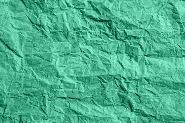 Grüne zerknitterte Papierstruktur, die zerknittert ist und eine raue Textur hat.