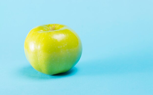 Grüner Apfel auf einem Blau