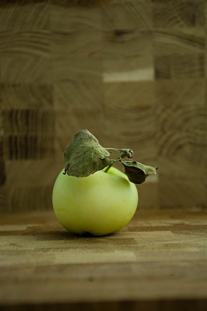 Grüner Apfel auf einem hölzernen Hintergrund.