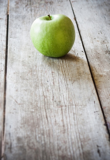 grüner Apfel auf Holztisch