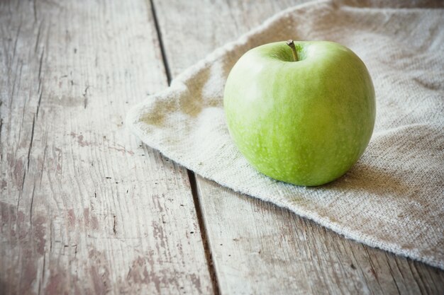 grüner Apfel auf Holztisch