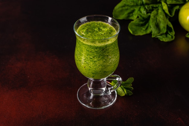 Grüner Apfel Smoothie des Ingwers auf konkretem Hintergrund.