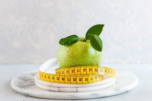 Grüner apfel und zentimeter. frisches obst, konzept zur gewichtsreduktion, diät, ketogene diät, intermittierendes fasten