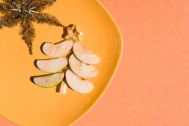 grüner Apfel-Weihnachtsbaum auf einem orangefarbenen Teller