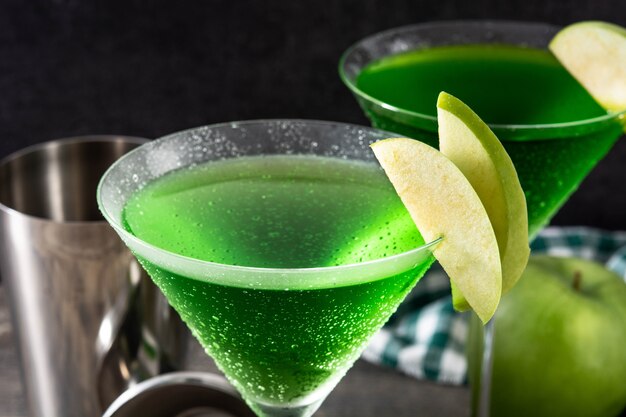 Grüner Appletini-Cocktail im Glas auf schwarzem Hintergrund