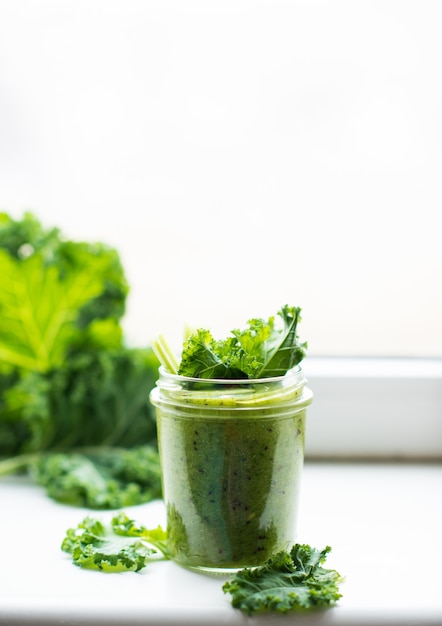 Grüner Detox-Cocktail mit Grünkohlsalat, vegetarischer gesunder Smoothie in einem Glas, selektiver Fokus