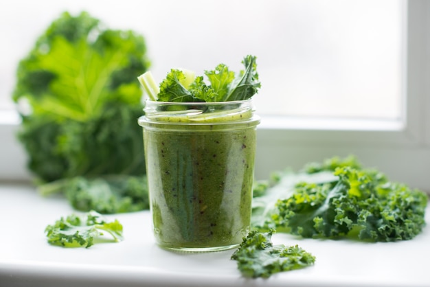 Grüner Detox-Cocktail mit Grünkohlsalat, vegetarischer gesunder Smoothie in einem Glas, selektiver Fokus