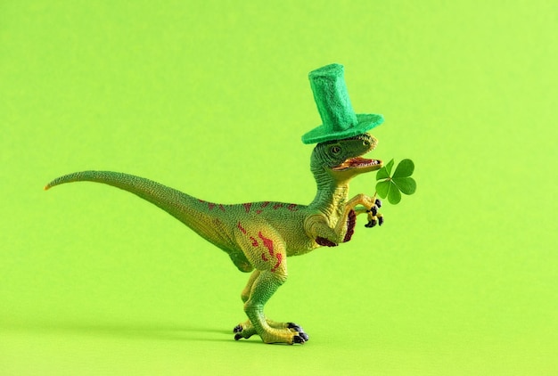 Grüner Dinosaurier mit grünem Hut hält ein Kleeblatt in der Hand. Breites Banner, Kopierraum