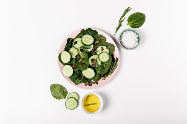 Grüner frischer Salat aus Spinat, Gurke und Kürbiskernen.