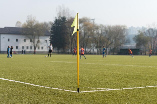 Grüner künstlicher Fußballplatz mit gelber Eckfahne