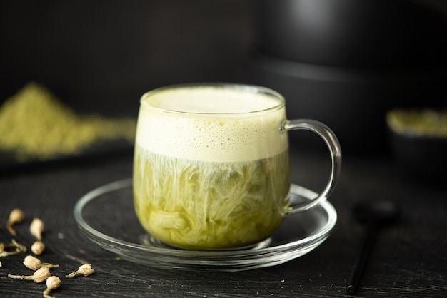 Grüner Matcha-Tee mit Milch in einer Glasschale