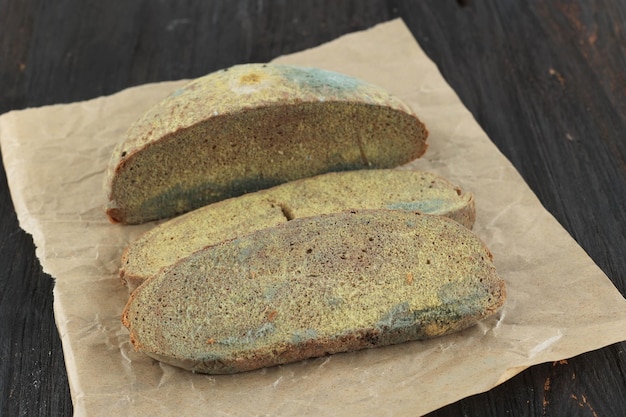 Grüner Mehltau auf einem altbackenen Brot Oberfläche von verschimmeltem Brot Verdorbenes Brot mit Schimmel Schimmelpilz auf faulem Brot