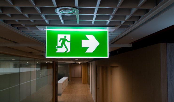 Foto grüner notausgangzeichenfall an der decke im büro.