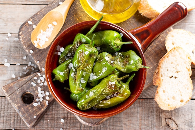 Grüner Pfeffer Padron nach spanischer Art in einer Pfanne auf einem Holztisch gebacken oder gebraten