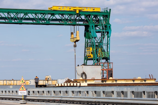 Grüner Portalkran nahe der Straßenbrücke.