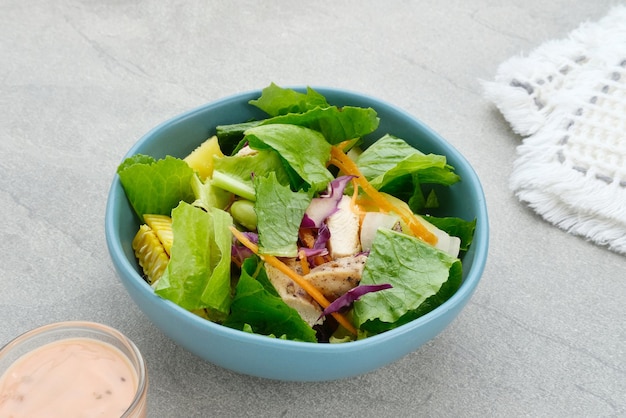 Grüner Salat aus grünen Blättern, gemischtes Gemüse mit Mayonnaise-Sauce, serviert in einer Tosca-Schüssel