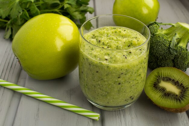 Grüner Smoothie auf dem grauen hölzernen Hintergrund