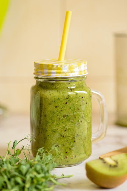 Foto grüner smoothie aus kiwi- und erbsensprossen.