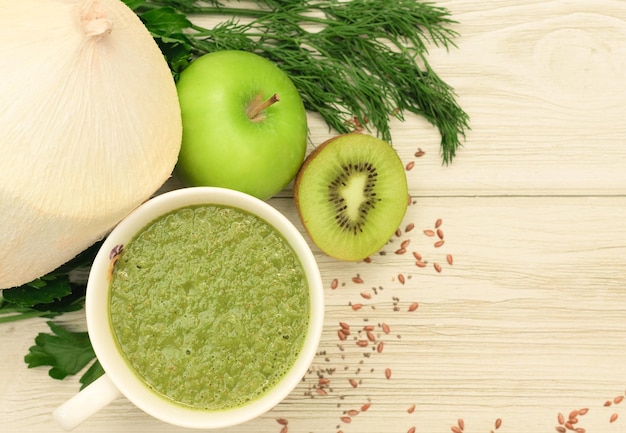 Grüner Smoothie aus Äpfeln, Kiwis, Grüns, Leinsamen und Chiasamen mit Kokosmilch, gesunde Ernährung