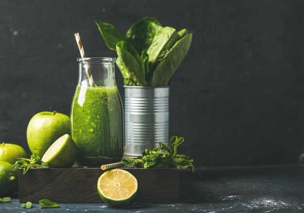 Grüner Smoothie in Glasflasche mit Kopienraum der frischen Früchte