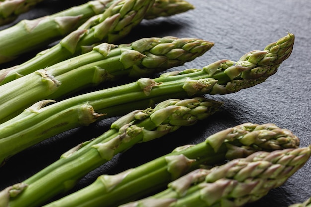 Foto grüner spargel auf schwarzem hintergrund mit kopierraum