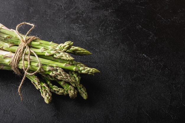 Grüner Spargel auf schwarzem Hintergrund mit Kopierraum