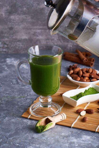 Grüner Tee Matcha im Glas auf grauem Steintisch