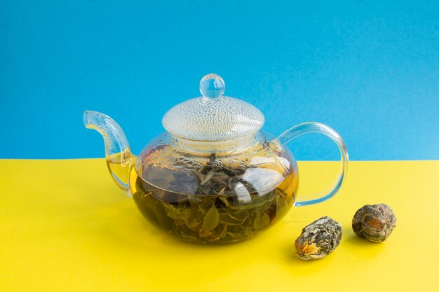 Grüner Tee mit Lotusblume in der Glasteekanne. Nahansicht. Speicherplatz kopieren.