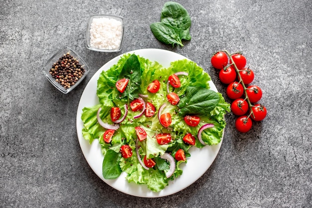 Grüner veganer Salat aus Gemüse und grünen Blättern mischen sich auf SteinhintergrundGesunde Ernährung