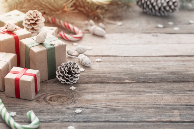 Grüner Weihnachtszweig und Geschenke auf hölzernem Hintergrund