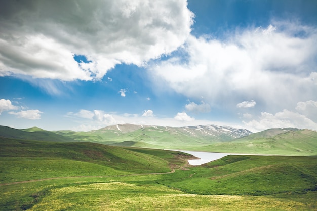 Grüner Wiesensee und blauer Himmel mit Wolken, die Armenien erkunden