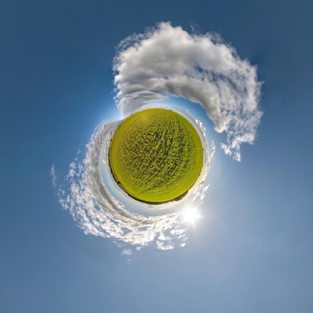 Grüner winziger Planet im blauen Himmel mit Sonne und schönen Wolken Transformation des sphärischen Panoramas 360 Grad Sphärische abstrakte Luftaufnahme Krümmung des Weltraums