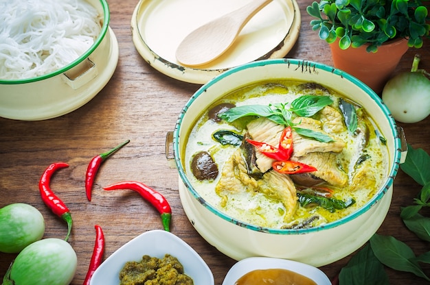 Foto grünes curryhuhn des thailändischen lebensmittels auf hölzernem hintergrund.