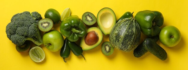 Grünes Gemüse und Obst auf gelber Oberfläche