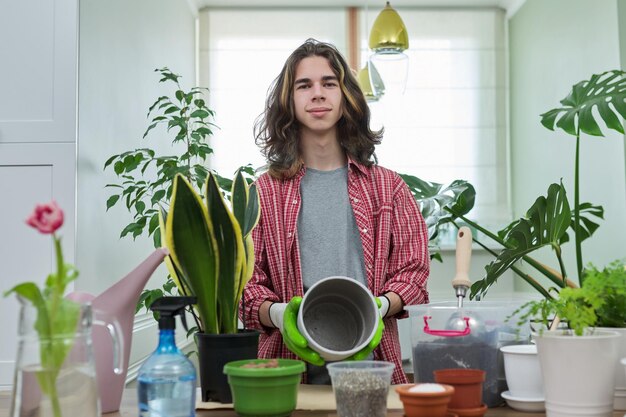 Grünes Öko-Hobby des jungen männlichen Teenagers, der Pflanzenbodentopf zeigt