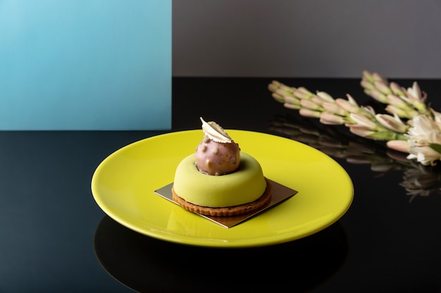 Grünes modernes rundes mousse-dessert auf glänzendem tisch