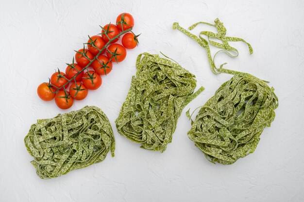 Grünes rohes Tagliatelle-Set, auf weißem Steintischhintergrund, Draufsicht flach