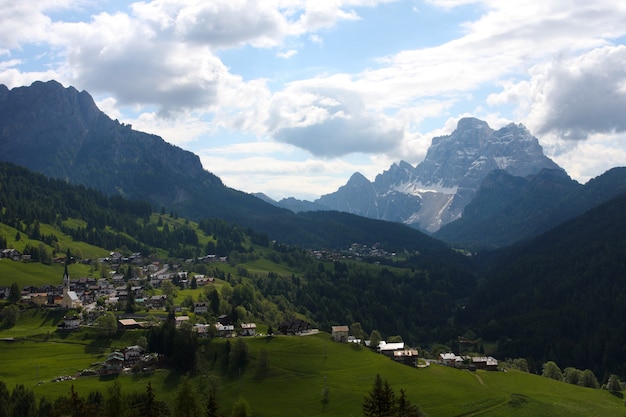 Grünes Tal mit schneebedeckten Bergen in der Ferne, Italien, Alpen