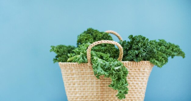 Grünkohlsalat in Öko-Strohsack auf blauem Hintergrund