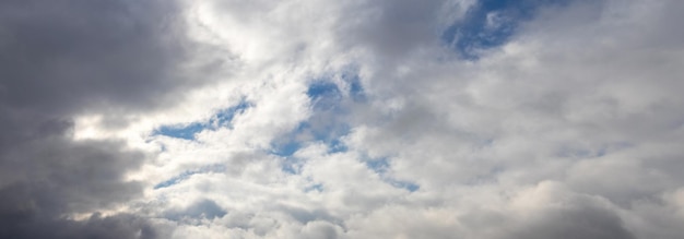 Gruesas nubes blancas y grises en el cielo azul cuando hace sol