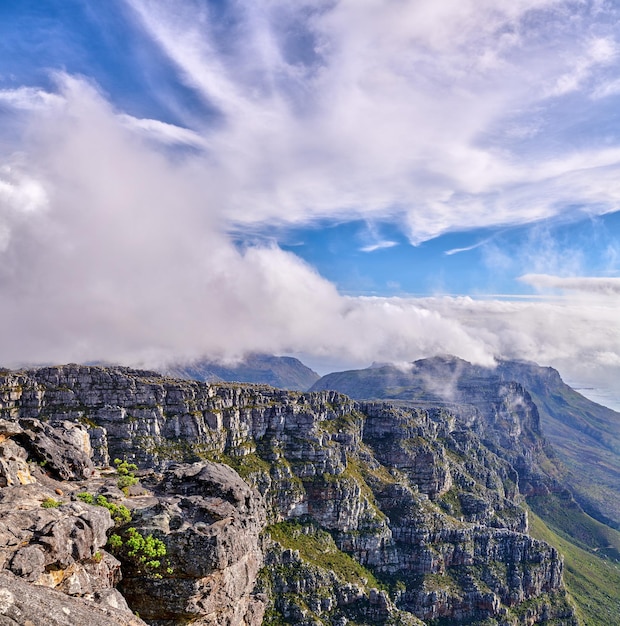Gruesas nubes formándose en la cima de Table Mountain en Ciudad del Cabo con copyspace Terreno rocoso en un día soleado con sombras nubladas naturaleza pacífica en armonía con relajantes vistas de plantas y paisajes