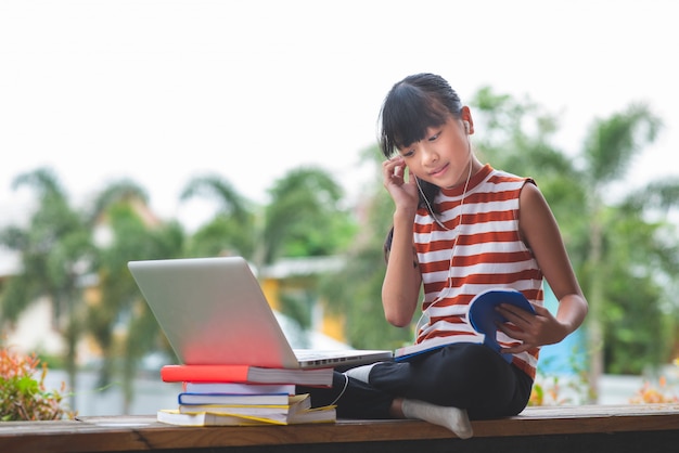 Grundschüler in Asien sitzen und lernen in einiger Entfernung von zu Hause. Online-Bildungskonzept