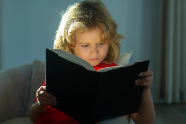 Grundschule Nerd Junge Schüler las Buch junger Teenager Junge allein zu Hause rotes Buch Kindheit