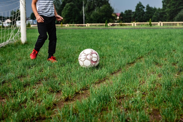 Grundschulkinder, die auf dem Feld Fußball spielen.