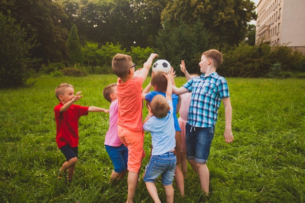 Grundschulkinder spielen beim Aufheben des Balls im Hinterhof